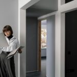 Businesswoman reviewing architectural plans in a modern apartment interior.