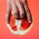 person holding red pomelo fruit