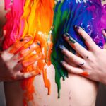 person with green yellow and pink paint on hand