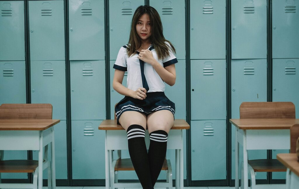 woman in white shirt and black shorts sitting on gray metal locker